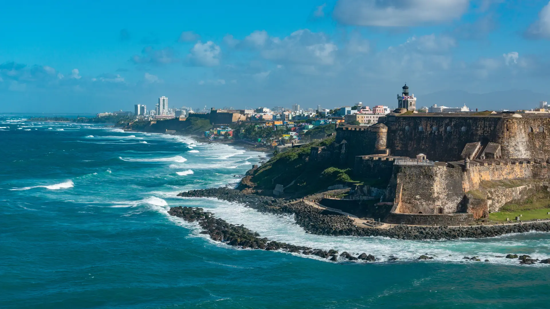 Castillo San Felipe del Morro’s stone walls and green lawn above turquoise Atlantic surf in San Juan, Puerto Rico
