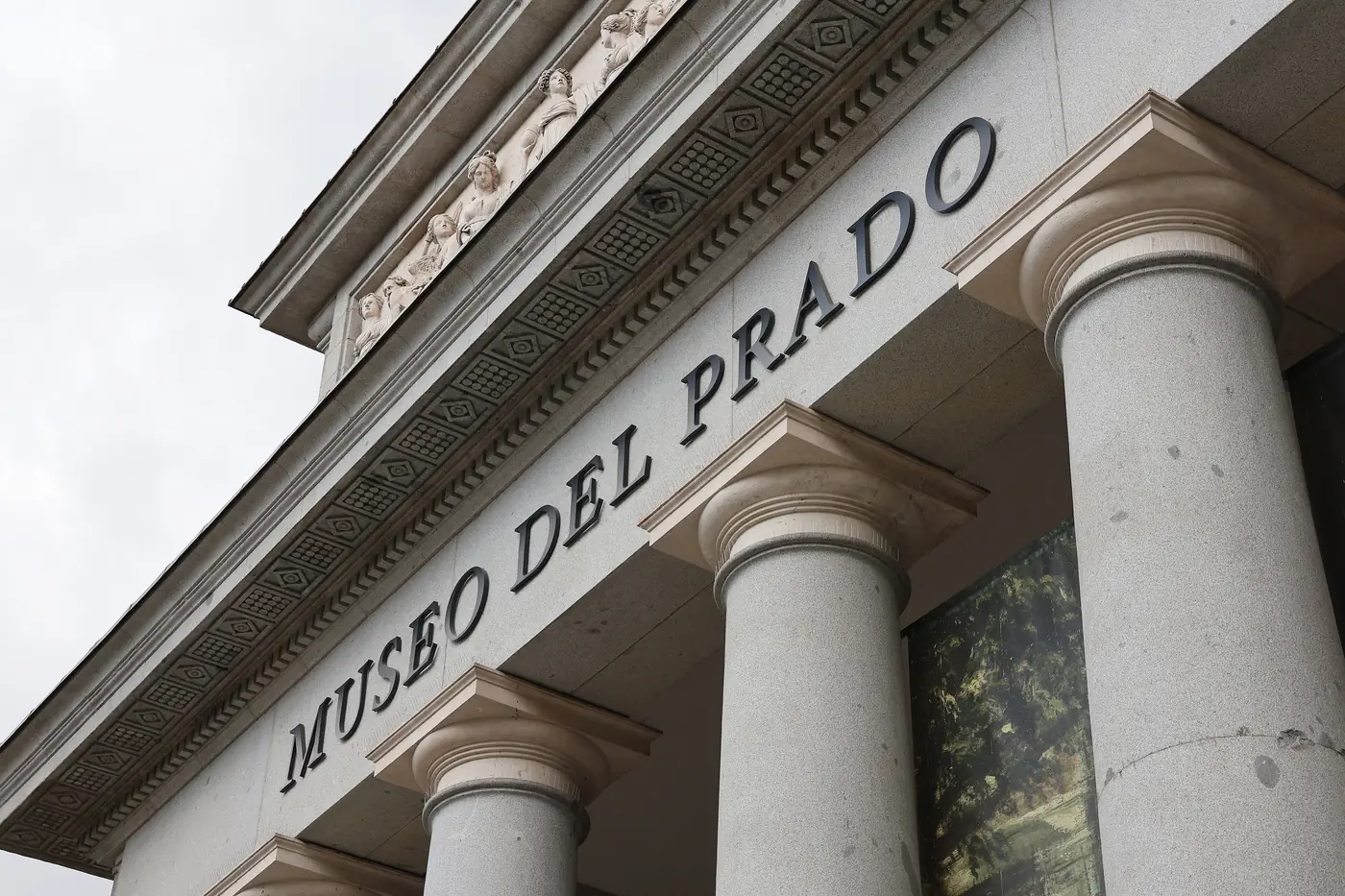 The Villanueva building of the Museo Nacional del Prado in Madrid, its long neoclassical colonnaded facade in warm afternoon light