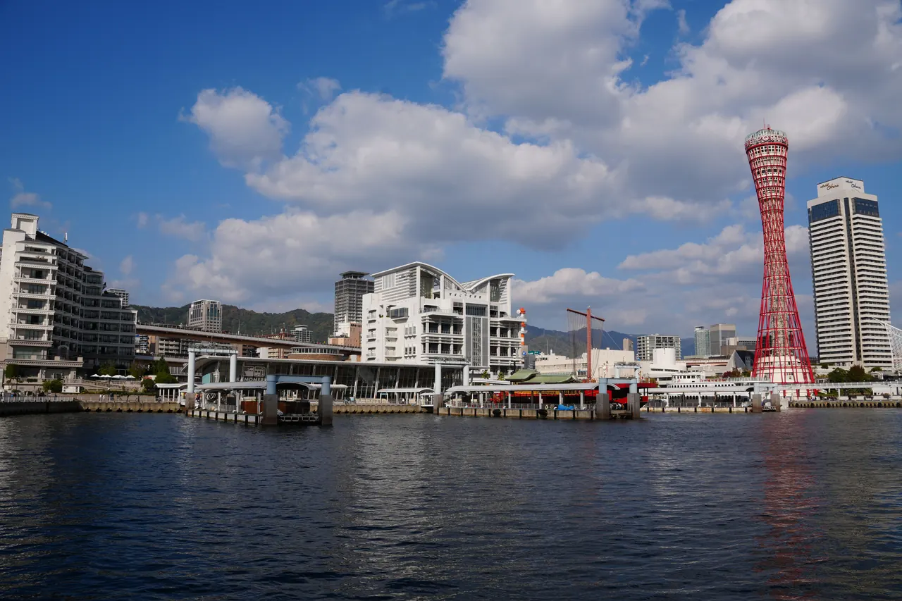 Kobe Harbor in Japan with the red lattice Port Tower rising above the waterfront under a clear sky