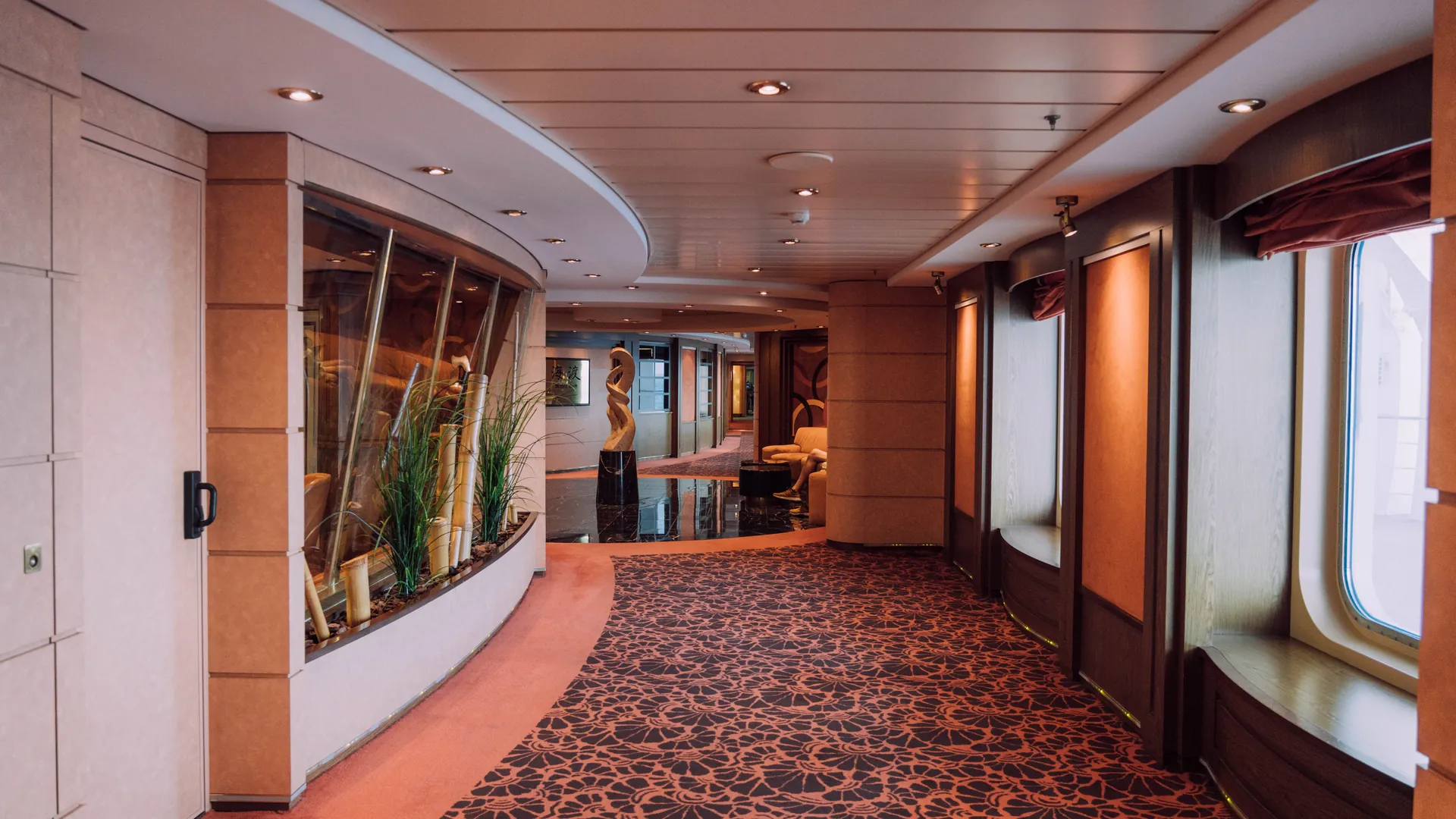 An empty, softly lit corridor aboard a luxury cruise ship