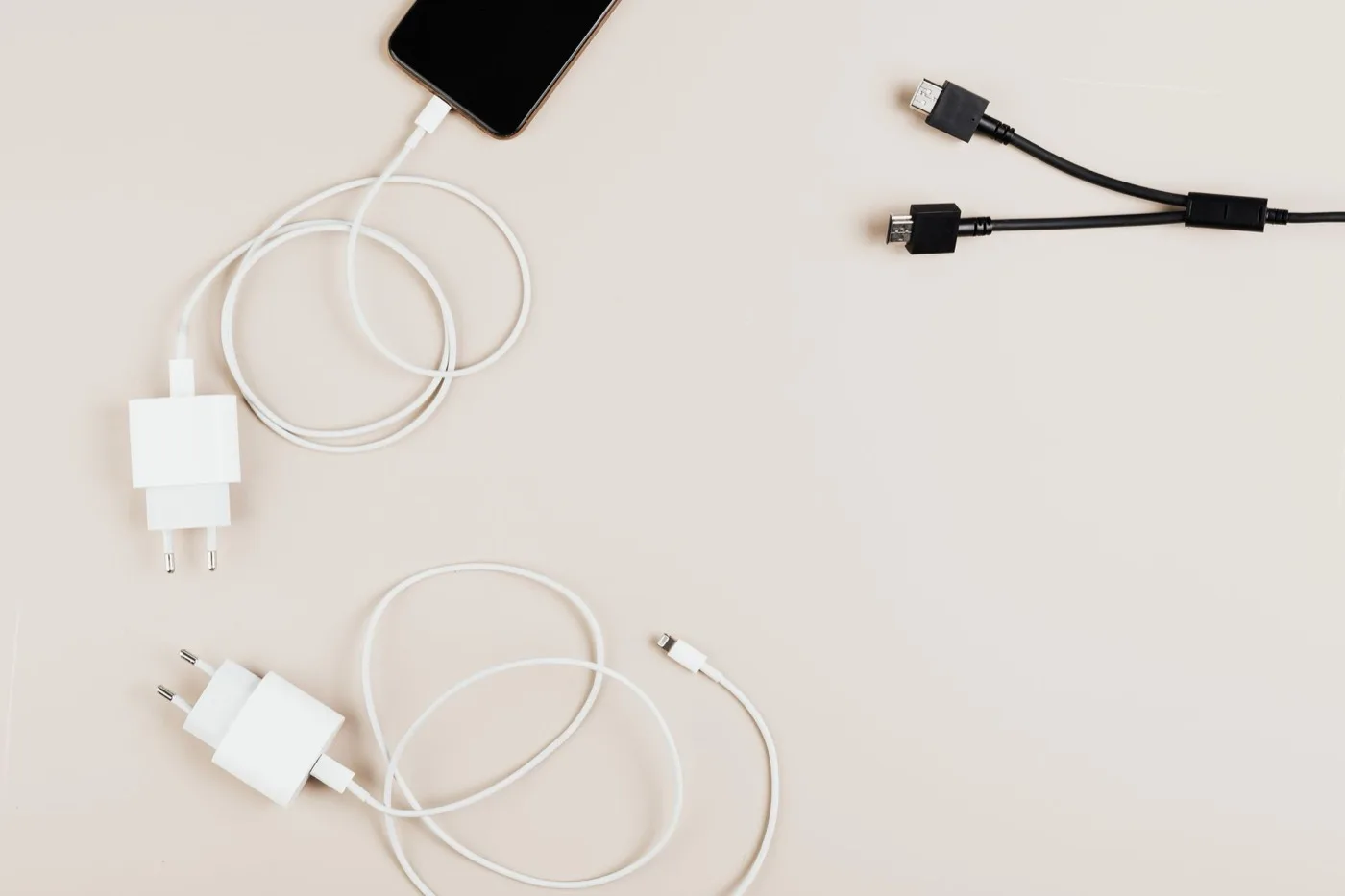 Phone chargers, plugs and USB cables laid out flat on a surface