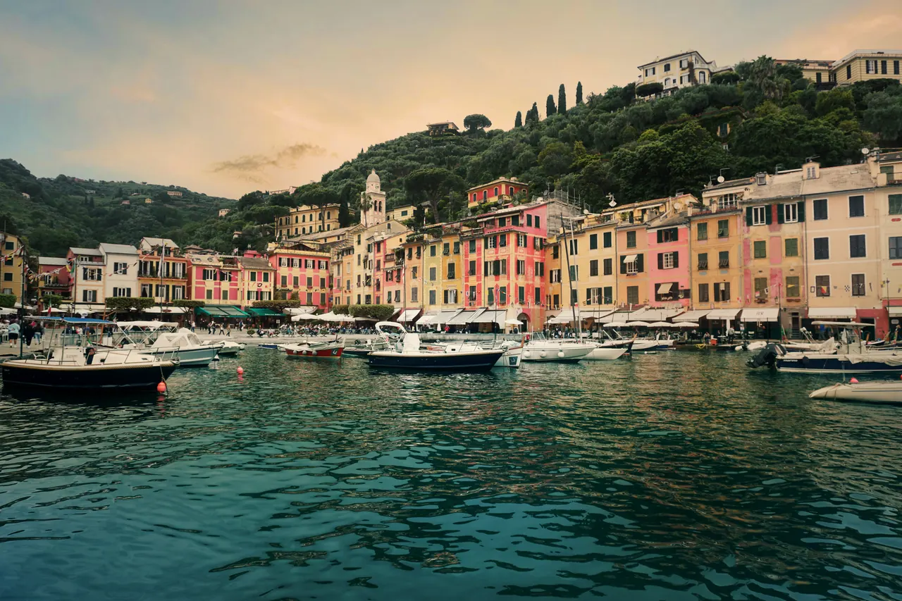Colorful buildings and boats at Portofino harbor, Italy on a serene day.