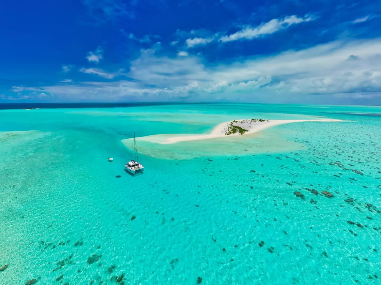 Stunning aerial view of a sailboat near a pristine sandbar in Mauritius’ turquoise waters.