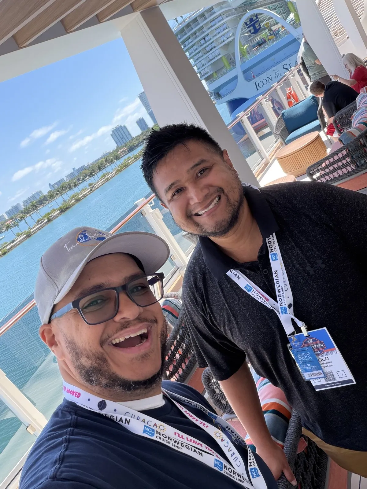 Paolo Melendez and Miguel of TravelByTrinidad onboard NCL Luna at Port Miami, with Icon of the Seas visible in the background