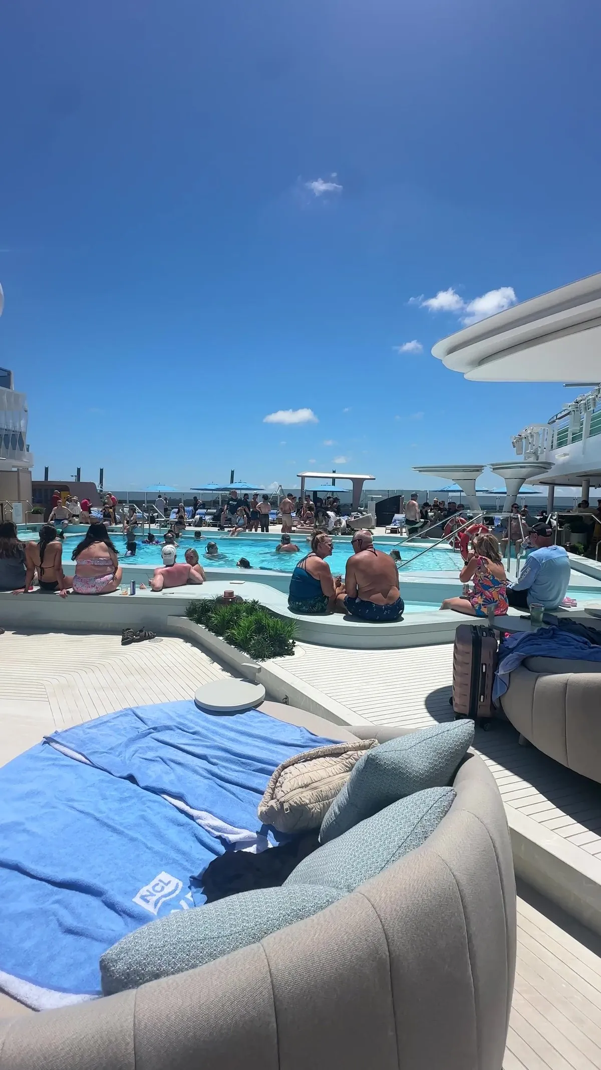 NCL Luna main pool deck with soft daybeds and layered seating