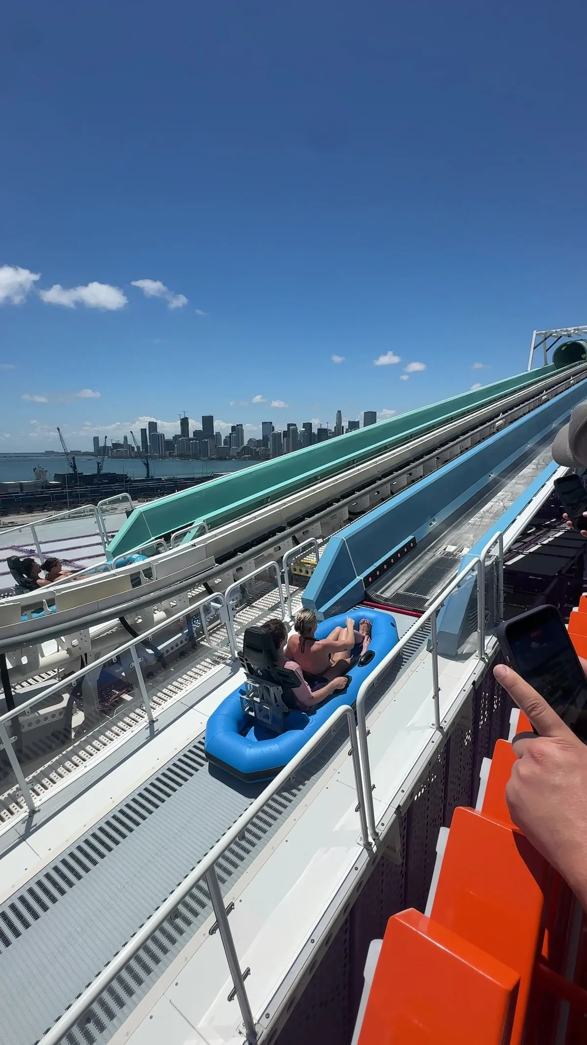 Top deck water slide attraction on NCL Luna with the Miami skyline in the distance