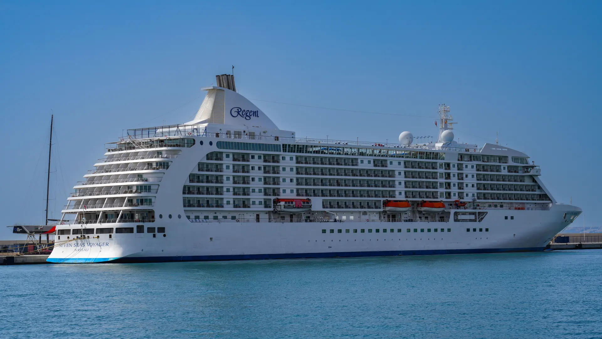 A large cruise ship berthed at a sunny port