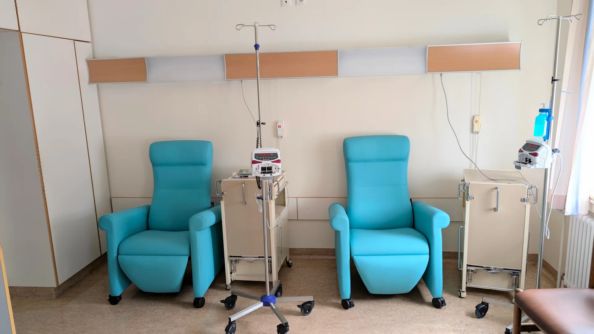 A calm clinical treatment room with infusion chairs and equipment