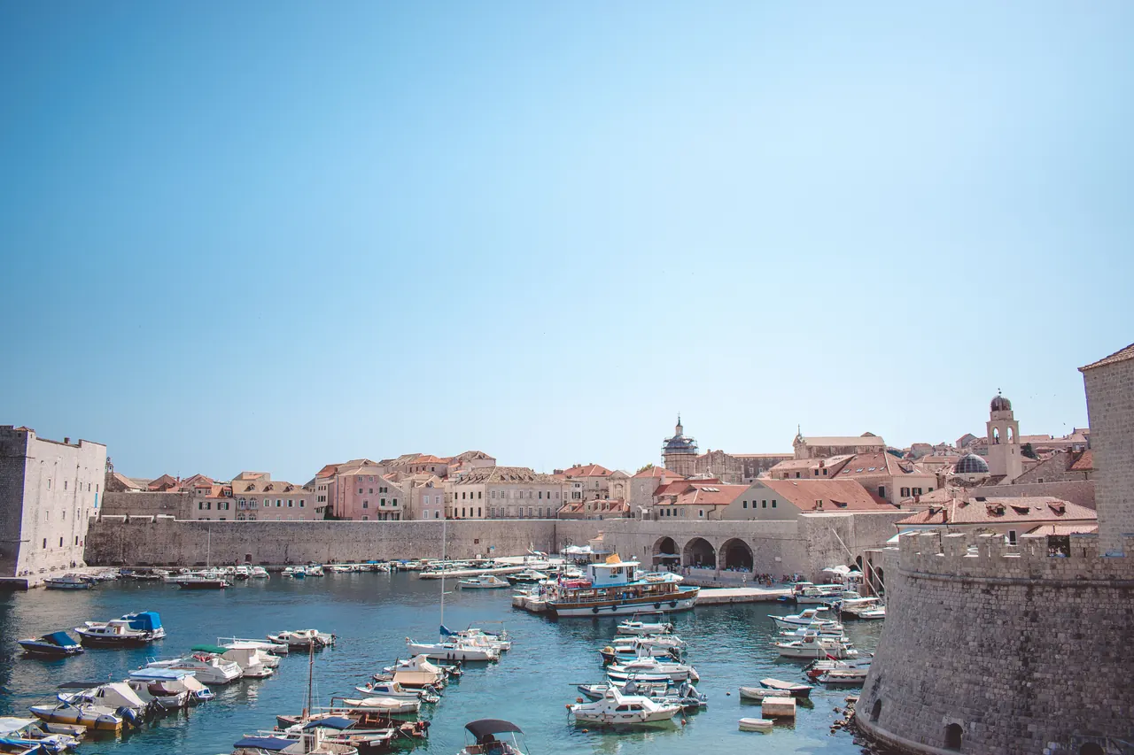 Dubrovnik's historic harbour with small wooden boats moored below the Old Town's stone walls