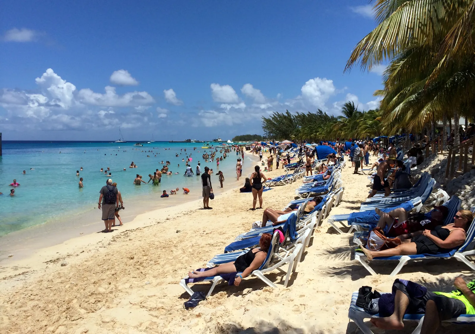 A wide pale beach on Grand Turk under a bright sky, turquoise shallows running out to deeper blue