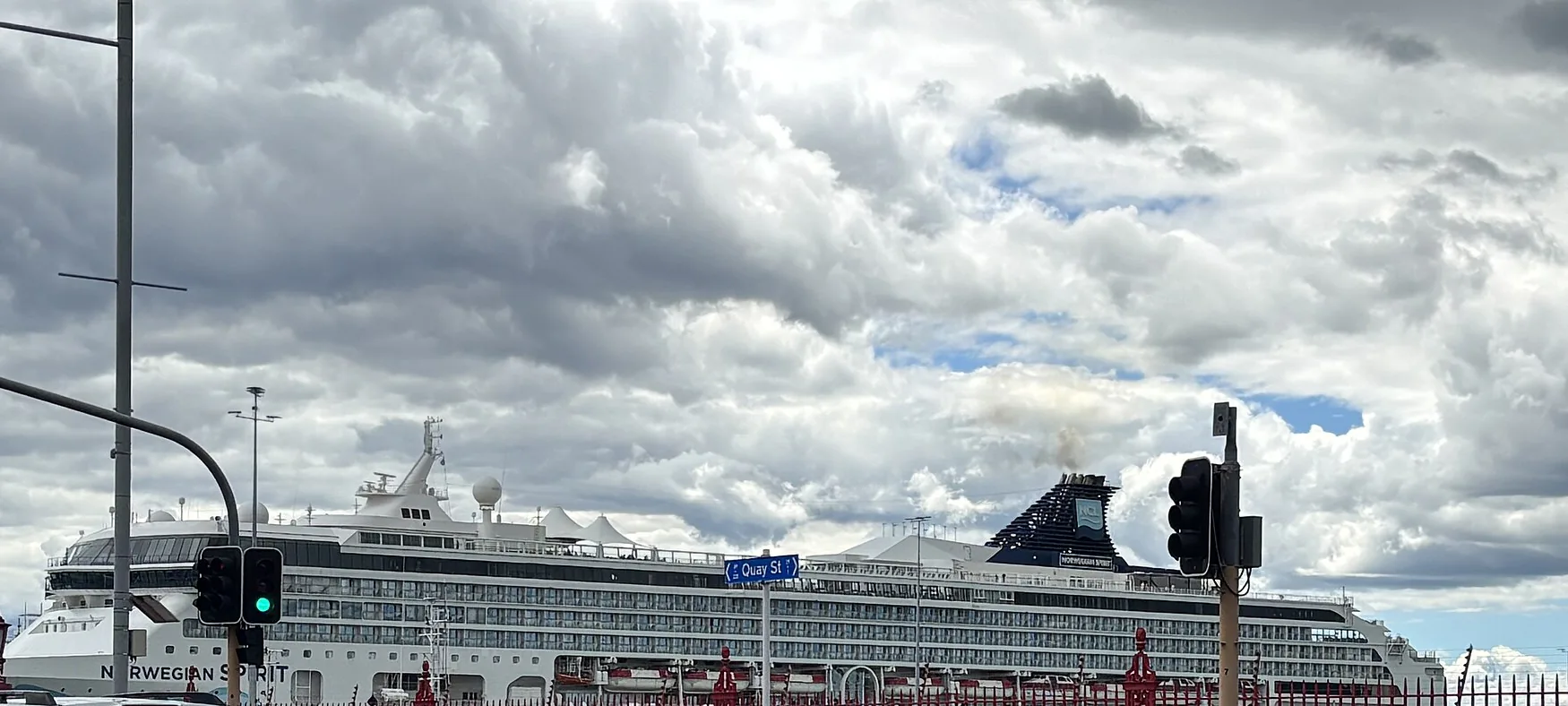 Norwegian Spirit alongside under heavy cloud — one of two NCL ships held offshore when Hawaii's ports closed during Tropical Storm Lala