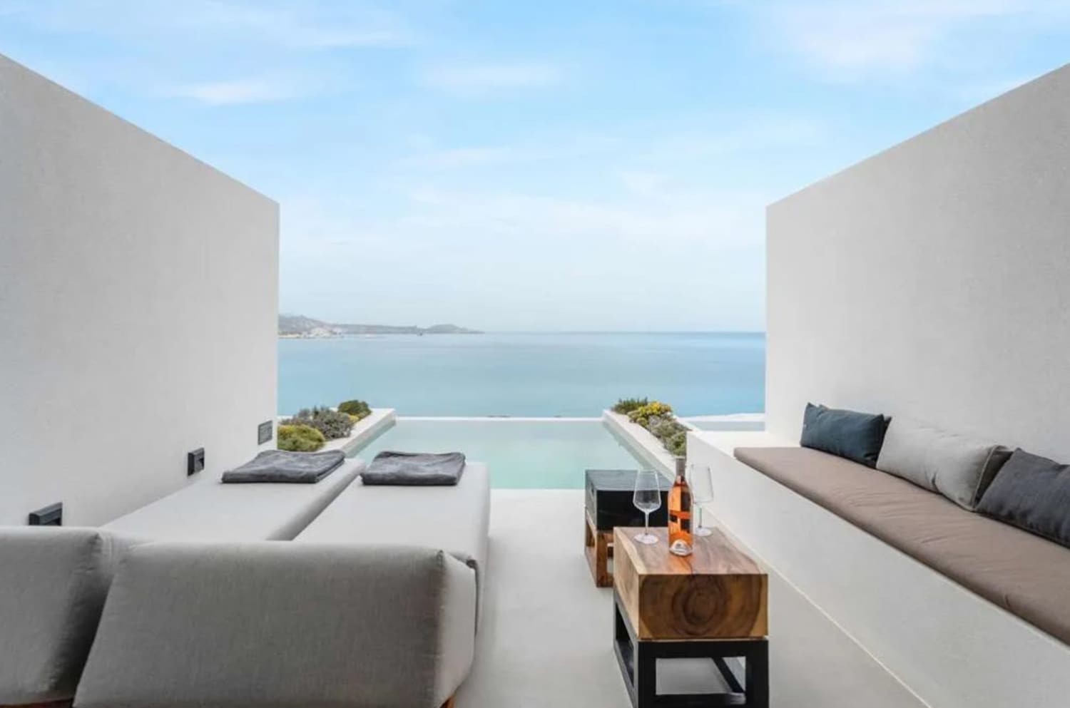 A sleek all-white hotel terrace with a private plunge pool facing the Aegean at Domes White Coast Milos