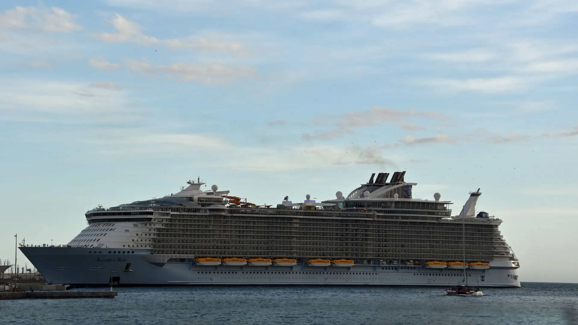 Allure of the Seas berthed at Málaga, the Royal Caribbean ship Atlantis has chartered in full for March 2027