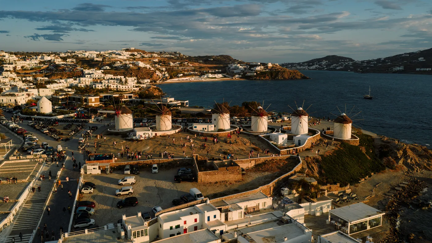 The windmills above Mykonos Town at sunset, with the whitewashed houses of Little Venice below