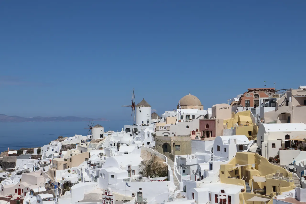 Explore Oia, Santorini with its iconic white buildings, blue skies, and stunning sea views. Perfect for travel enthusiasts.