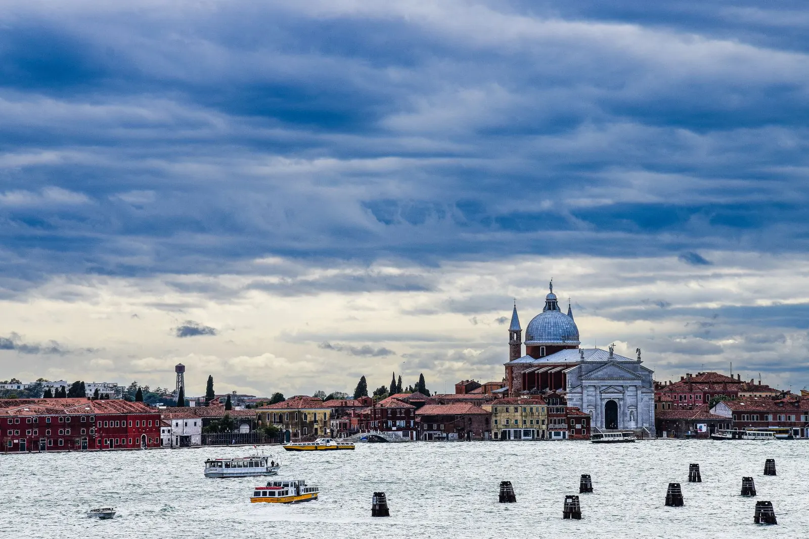 The Giudecca Canal in Venice under heavy cloud, with Il Redentore church on the far bank and only small vaporetti on the water