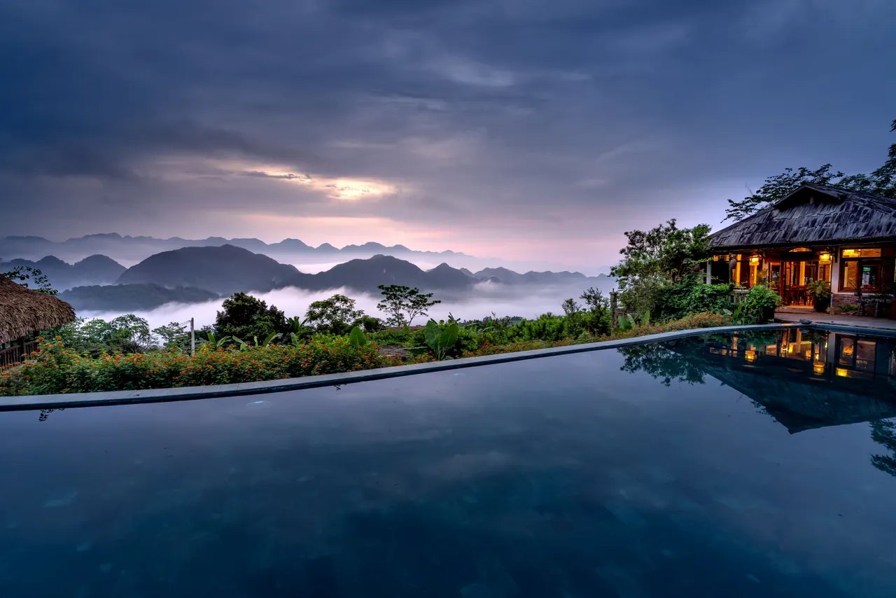 Scenic mountain view with infinity pool at a luxurious resort during twilight, perfect for relaxation.