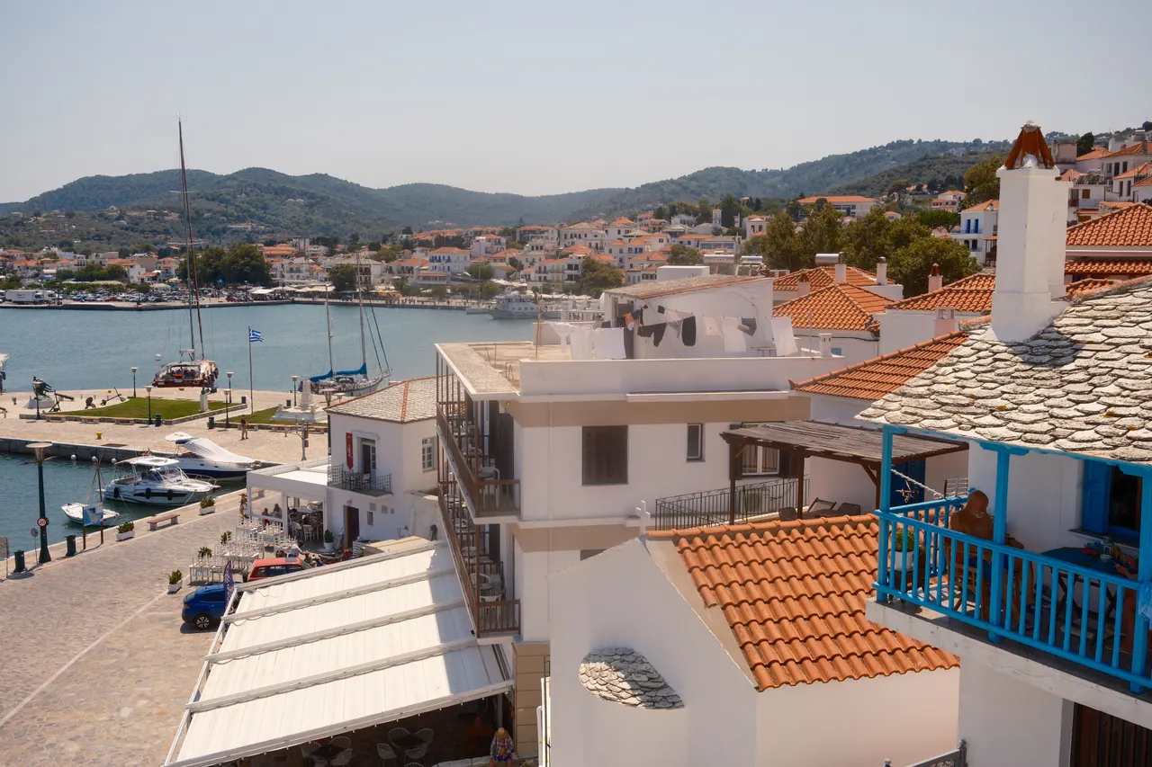 Charming coastal view of Skopelos, Greece showcasing rustic architecture and serene harbor.