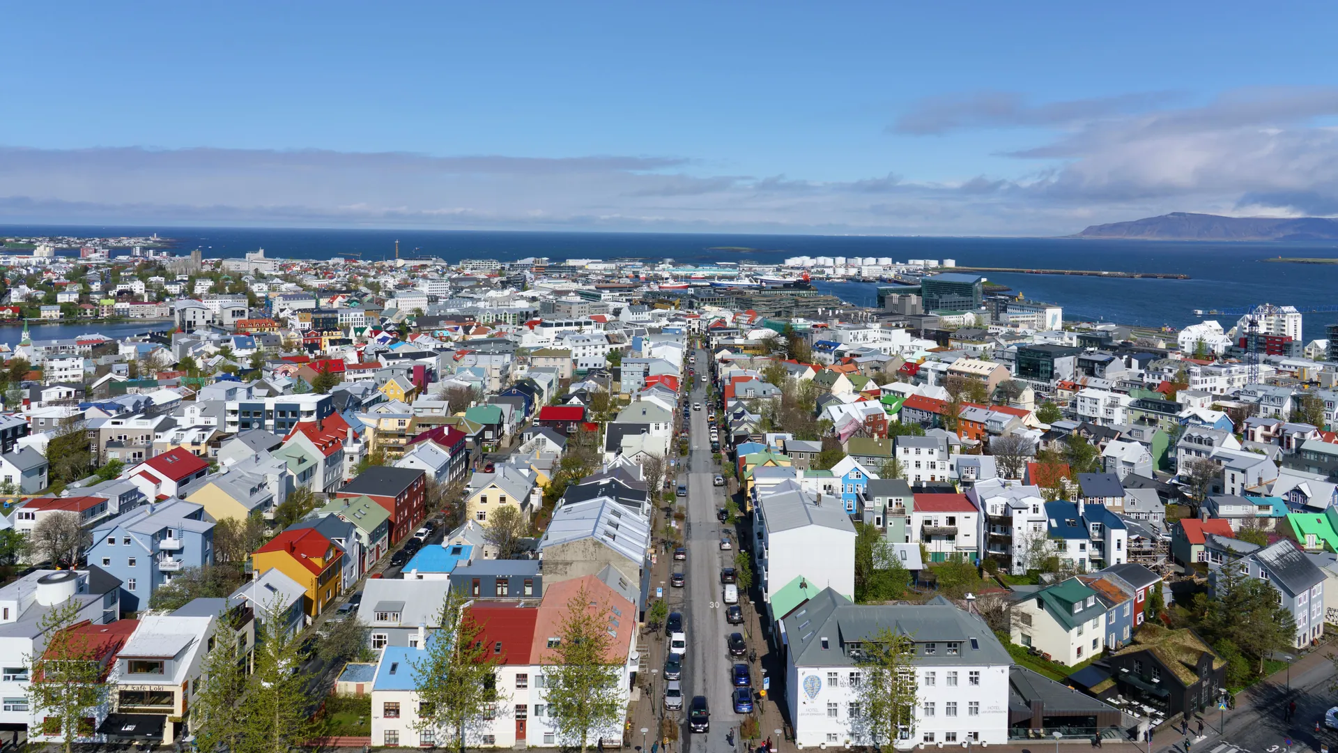 Aerial view of Reykjavík’s colorful rooftops with the sea beyond