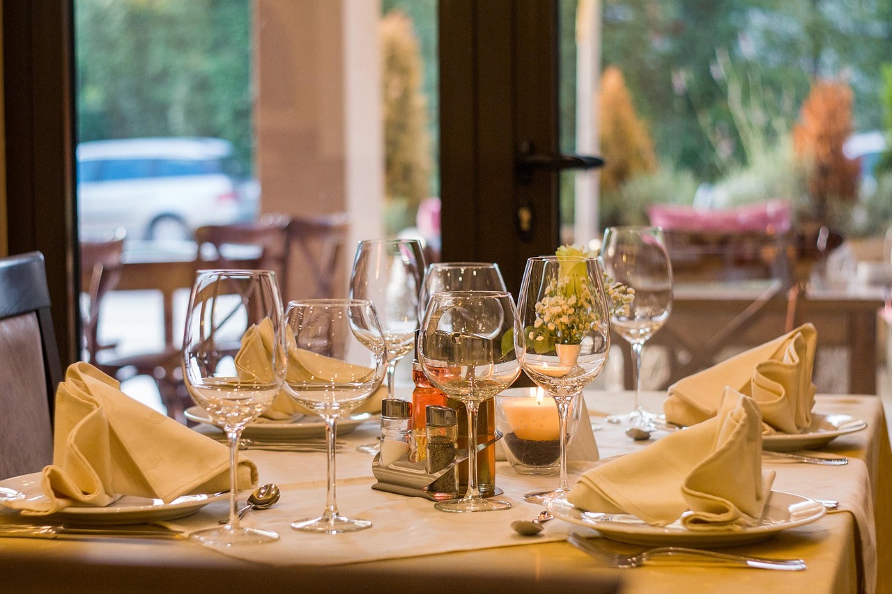 A communal dining table set for an evening service with warm candlelight