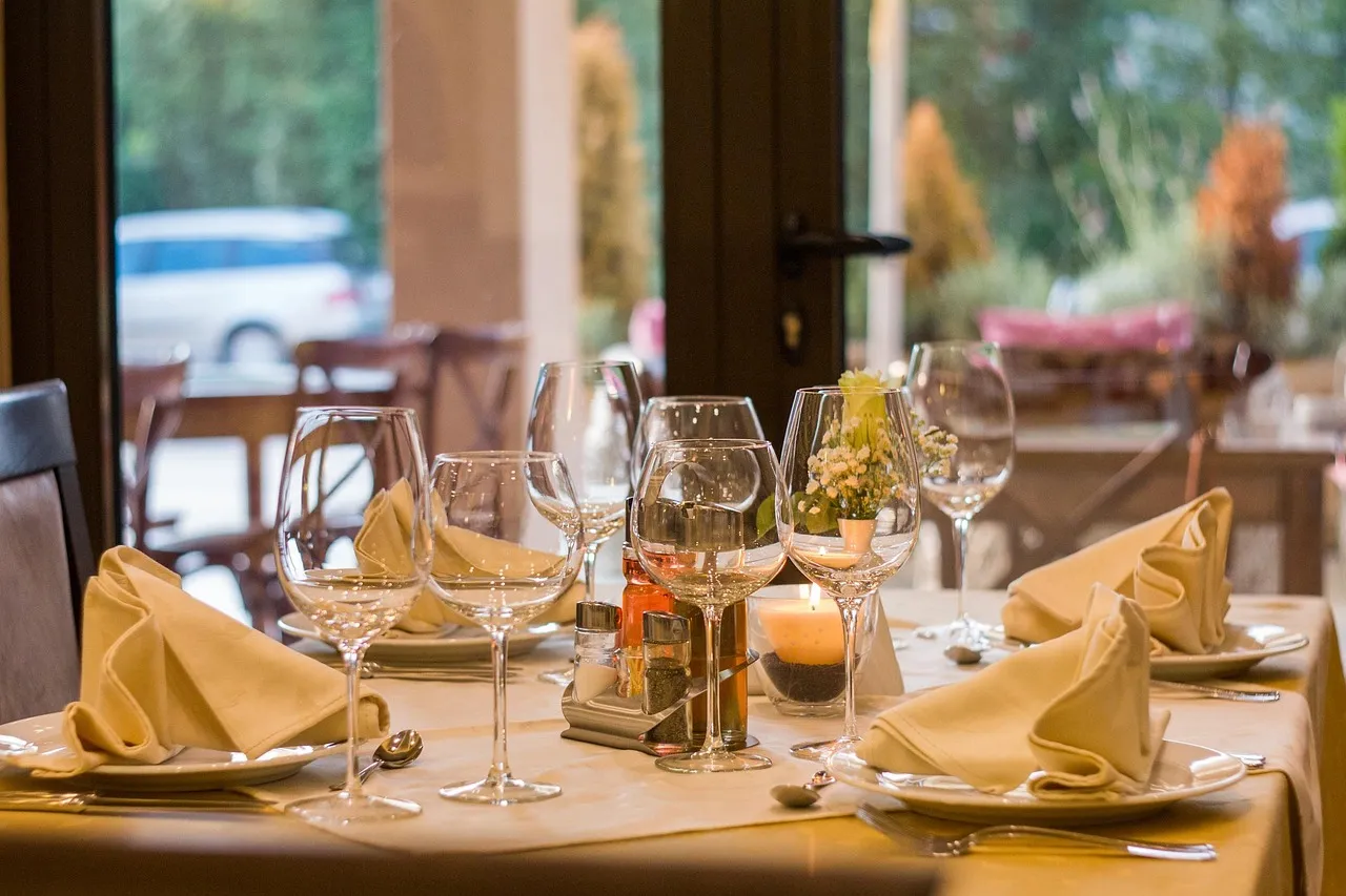 A communal dining table set for an evening service with warm candlelight