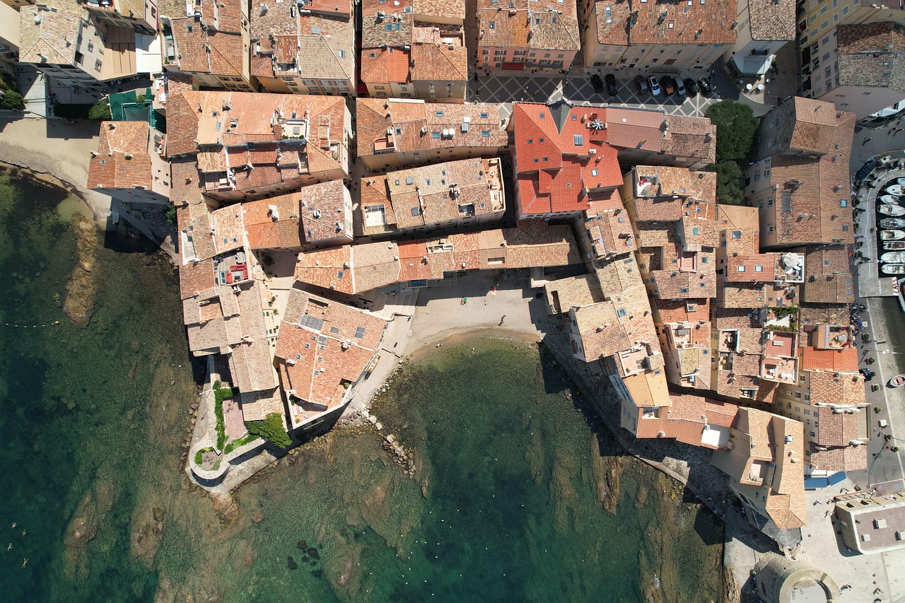 A sun-drenched Mediterranean port town with colorful buildings along the waterfront