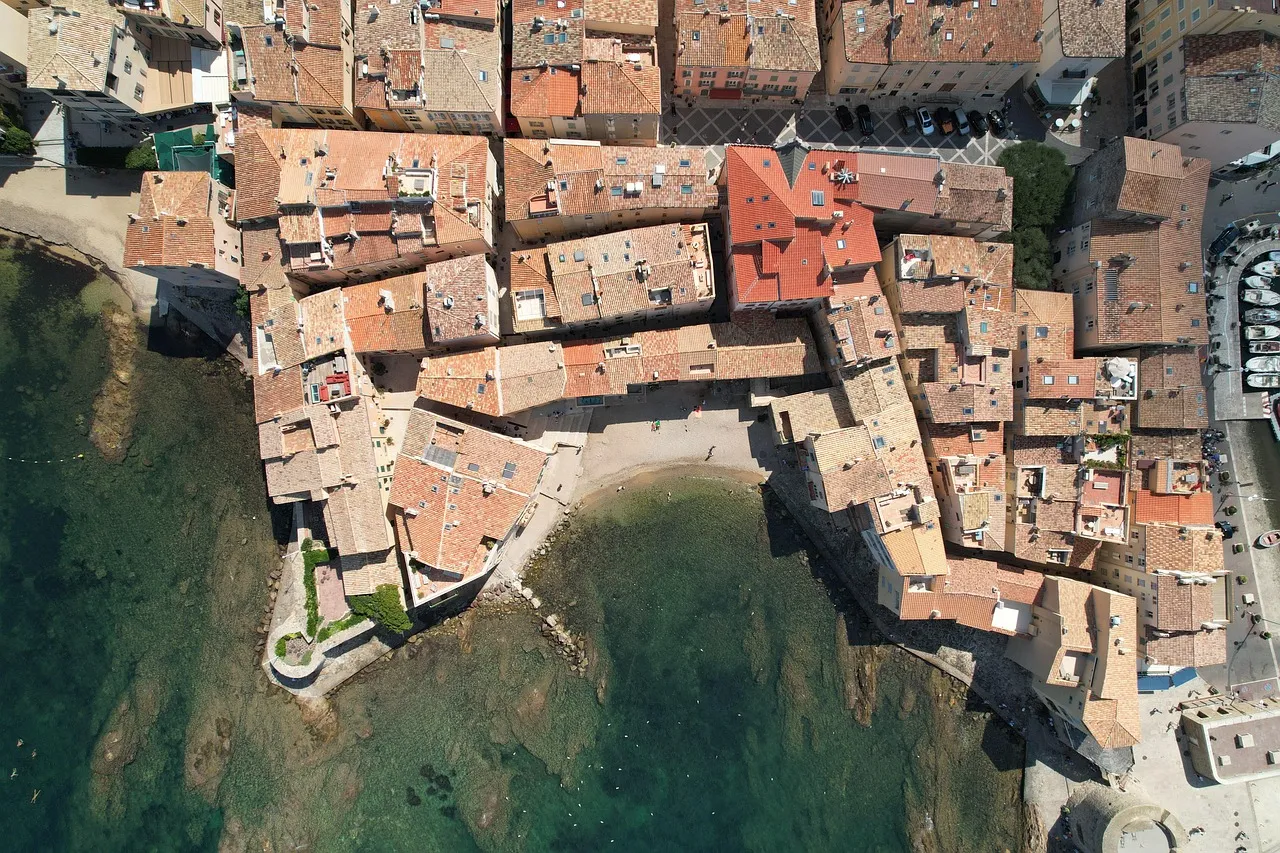 A sun-drenched Mediterranean port town with colorful buildings along the waterfront