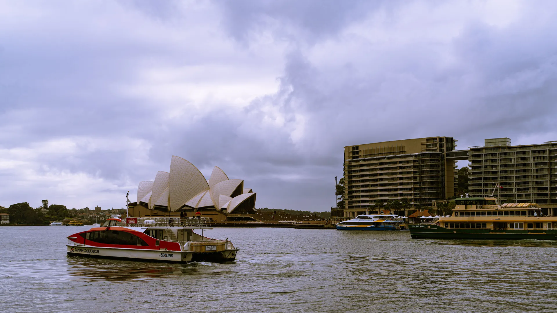 Sydney Opera House and the harbor under a cloudy sky
