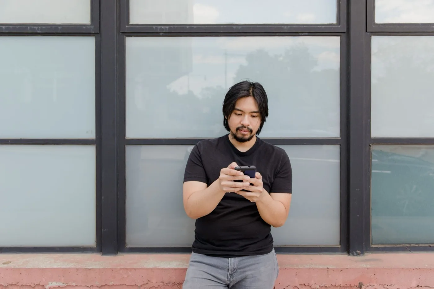A traveller checking a phone while standing outdoors in an unfamiliar city