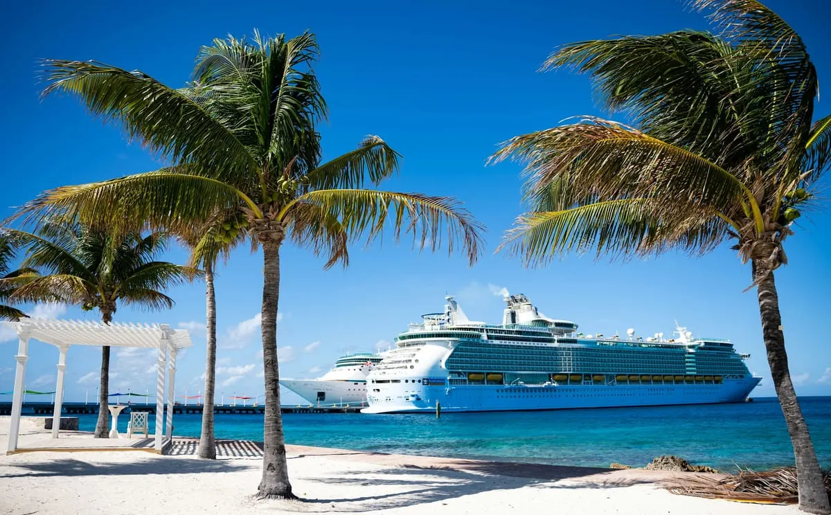A cruise ship at sea at dusk — 2026 and 2027 fares are climbing across the major lines